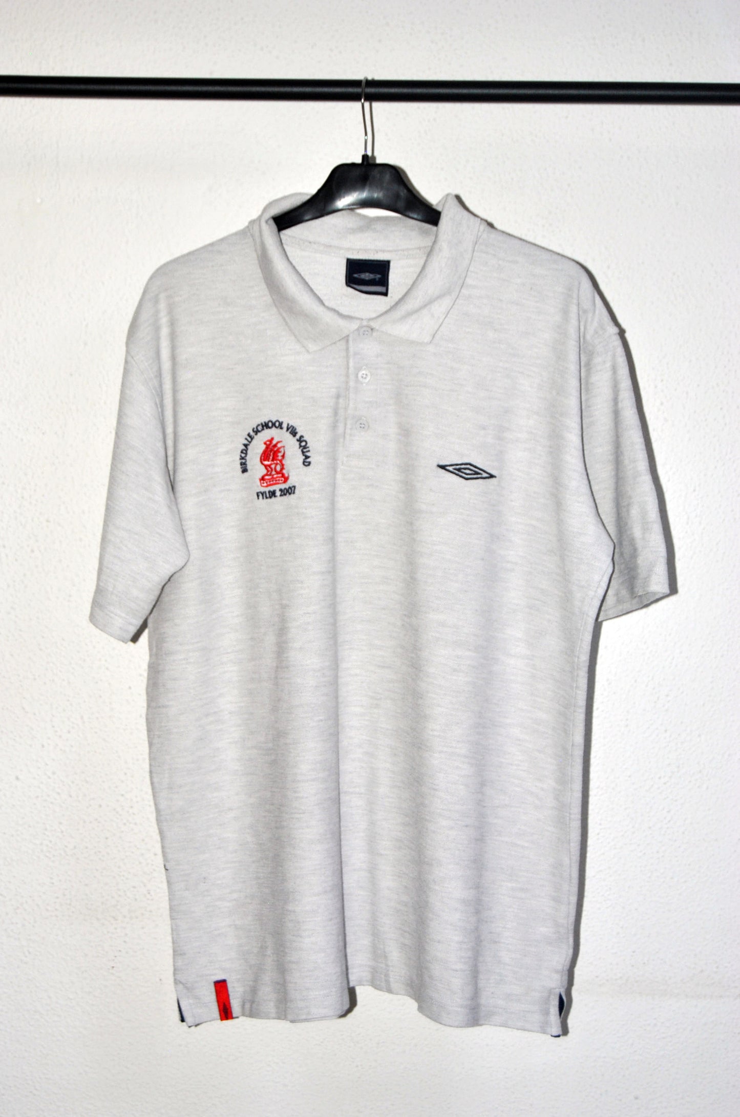 Polo Umbro de color gris con logo bordado Birkdale School. Talla L. Segunda Mano
