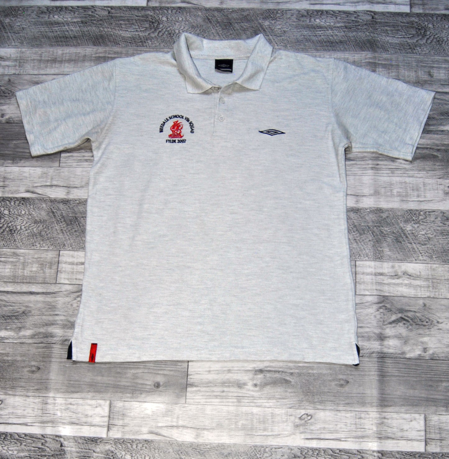 Polo Umbro de color gris con logo bordado Birkdale School. Talla L. Segunda Mano
